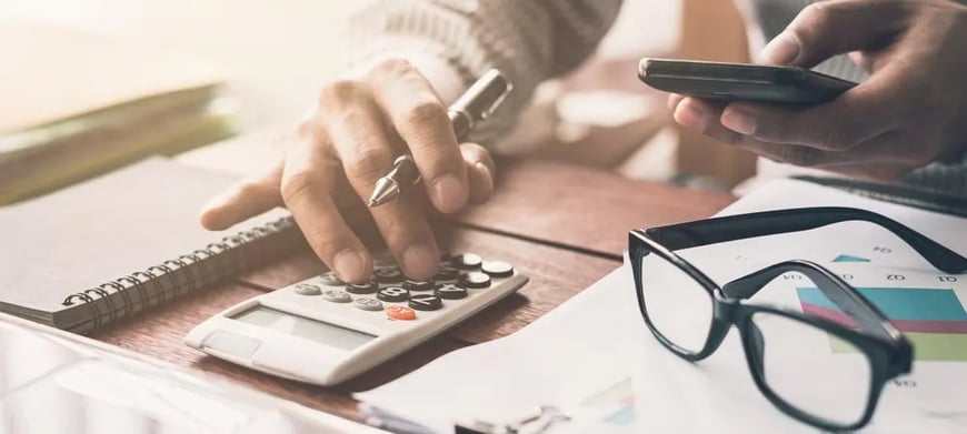 Man making calculations and looking on his phone