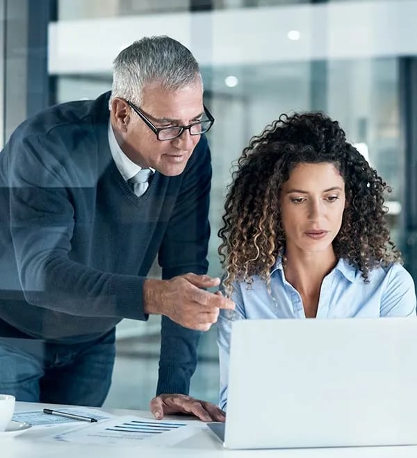 Two team members work on on a computer