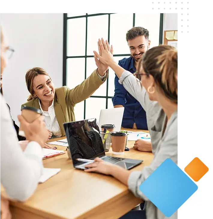 A team is happy and high-fives in an office setting